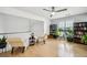 Bright loft with hardwood floors, natural light, neutral chairs, and black bookshelves with plants at 3800 Lake Pass Ln, Suwanee, GA 30024