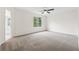 Large bedroom with neutral carpet, ceiling fan, and a view of the backyard at 5615 Crystal Hl, Stone Mountain, GA 30088