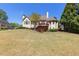 Back exterior of home with a well-maintained lawn and mature trees at 5055 Stefan Ridge Way, Buford, GA 30519