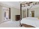 Main bedroom with carpet, tray ceiling, access to patio, and ensuite bathroom at 5055 Stefan Ridge Way, Buford, GA 30519