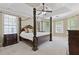 Main bedroom suite with tray ceiling, four-poster bed, and natural light from many windows at 5055 Stefan Ridge Way, Buford, GA 30519
