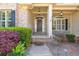 Charming front entrance with a decorative wreath, stone accents, and well-maintained landscaping at 5055 Stefan Ridge Way, Buford, GA 30519