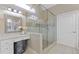 Bathroom featuring glass enclosed shower with stone tile accents and vanity with makeup table at 5055 Stefan Ridge Way, Buford, GA 30519