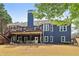 Expansive backyard featuring a deck, patio, and lush lawn with a distinctive blue-painted chimney at 2305 Stonevalley Ct, Cumming, GA 30041