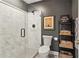 Bathroom offers a sleek glass-enclosed shower, modern toilet, and decoratively styled shelving at 2305 Stonevalley Ct, Cumming, GA 30041