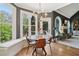 Cozy dining area with lots of natural light, hardwood floors, a modern chandelier, and outdoor views of mature trees at 2305 Stonevalley Ct, Cumming, GA 30041