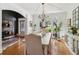 Bright dining room featuring hardwood floors, chandelier lighting, and large windows with backyard views at 2305 Stonevalley Ct, Cumming, GA 30041