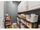 Well-organized pantry with shelving, baskets, and white cabinets provides lots of storage space for food and kitchen supplies at 2305 Stonevalley Ct, Cumming, GA 30041