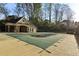Backyard pool with a protective cover, adjacent to a charming pool house and lush landscaping at 2305 Stonevalley Ct, Cumming, GA 30041
