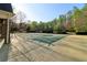 Swimming pool covered with a protective tarp surrounded by a patio with view of the green tennis court at 2305 Stonevalley Ct, Cumming, GA 30041