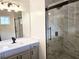 Modern bathroom featuring marble shower, gray vanity with white countertop, and stylish lighting at 801 Old Peachtree Nw Rd # 15, Lawrenceville, GA 30043