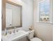 Half-bathroom featuring a modern vanity with a framed mirror and plenty of natural light at 2048 Violet Lane, Brookhaven, GA 30319