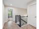 Bright hallway with hardwood floors, black metal stair rail, and view into bedroom at 2048 Violet Lane, Brookhaven, GA 30319