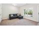 Comfortable living room area with plush carpet, sectional sofa, and large window for natural light at 2048 Violet Lane, Brookhaven, GA 30319