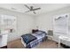 A bright bedroom with two windows, neutral walls, carpet, and a white headboard and small side table at 2051 Wildflower Way, Conyers, GA 30012