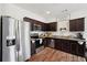 A spacious kitchen featuring stainless steel appliances and granite countertops and dark cabinets at 2051 Wildflower Way, Conyers, GA 30012