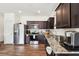 An eat-in kitchen with stainless steel appliances, granite countertops, and stylishly stained wood floors at 2051 Wildflower Way, Conyers, GA 30012