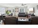 Cozy living room featuring plush leather seating, a ceiling fan, and natural light at 2051 Wildflower Way, Conyers, GA 30012