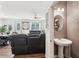 A contemporary powder room with a pedestal sink and an decorative mirror, adjacent to a living area at 2051 Wildflower Way, Conyers, GA 30012