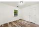 Well-lit bedroom featuring a window, door, and wood-look flooring at 831 Mercury Nw Dr, Atlanta, GA 30331