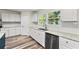 Bright kitchen featuring white cabinets, granite countertops, and stainless steel dishwasher at 831 Mercury Nw Dr, Atlanta, GA 30331
