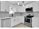 Well-appointed kitchen with stainless steel appliances, bright white cabinets, and elegant marble backsplash at 1318 Graymont Sw Dr, Atlanta, GA 30310