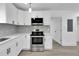 Modern kitchen with stainless steel appliances, white cabinets, marble countertops, and stylish pendant lighting at 1318 Graymont Sw Dr, Atlanta, GA 30310