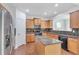 Well-lit kitchen featuring an island, stainless steel refrigerator, wooden cabinets, and dark countertops at 5480 Beaver Ridge Drive Dr, Cumming, GA 30040