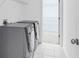 Laundry area featuring washer and dryer with white tile flooring at 5480 Beaver Ridge Drive Dr, Cumming, GA 30040