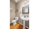 Elegant powder room with pedestal sink, hardwood floors, and stylish decor at 5628 Fallsbrook Nw Knl, Acworth, GA 30101