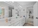 Well-lit bathroom with double sinks, a large mirror, and a doorway leading to another bedroom at 5628 Fallsbrook Nw Knl, Acworth, GA 30101