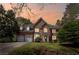 Charming brick home featuring a manicured lawn, arched entry, and attached two-car garage at dusk at 5628 Fallsbrook Nw Knl, Acworth, GA 30101