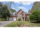 Charming brick home featuring a manicured lawn, arched entry, and attached two-car garage at 5628 Fallsbrook Nw Knl, Acworth, GA 30101