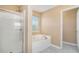 This bathroom features a glass enclosed shower and a soaking tub near a bright window at 1027 Fellowship Rd, Fairburn, GA 30213