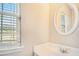 Bathroom featuring single sink vanity with large round mirror, white countertops, and faucet fixtures at 1027 Fellowship Rd, Fairburn, GA 30213
