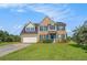 Inviting two-story home featuring brick facade, blue shutters, and landscaped front yard at 1027 Fellowship Rd, Fairburn, GA 30213