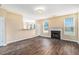 Open-concept living room with fireplace, wood floors, and ample natural light at 1027 Fellowship Rd, Fairburn, GA 30213