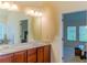 Elegant bathroom with double sinks, wood cabinets, and a view into the bedroom at 1800 Pearson St, Loganville, GA 30052