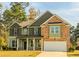 Inviting two-story home boasts a mix of brick and siding, complemented by a covered front porch and attached two-car garage at 1800 Pearson St, Loganville, GA 30052