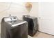 Modern laundry room with front-load washer and dryer, plus wire shelving at 1800 Pearson St, Loganville, GA 30052