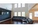 Spacious living room with high ceilings, dark hardwood floors, a large sectional couch, and multiple windows at 1800 Pearson St, Loganville, GA 30052