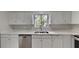 Bright kitchen with white cabinets, stainless steel dishwasher, and quartz countertops at 4111 Sweet Water Ct, Conyers, GA 30094
