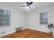 Bright bedroom with hardwood floors, two windows, and a ceiling fan at 1386 Sandy Ln, Decatur, GA 30032
