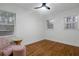 Bright bedroom with hardwood floors, chair, and a ceiling fan at 1386 Sandy Ln, Decatur, GA 30032