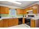 Classic kitchen with wooden cabinets, laminate countertops, and black appliances provides a functional cooking space at 2828 Marksman Trl, Austell, GA 30106