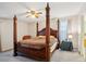 Spacious primary bedroom featuring a four-poster bed, ceiling fan, and bright natural light from the window at 2828 Marksman Trl, Austell, GA 30106