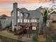 Beautiful two-story home with large windows and a wooden deck overlooking the backyard at sunset at 3887 Hickory Manor Dr, Suwanee, GA 30024