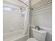Bathroom with white tiled walls, a shower with a curtain rod, and a toilet with decor on the tank at 3887 Hickory Manor Dr, Suwanee, GA 30024