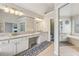 Bright, spacious bathroom featuring double sinks, granite countertops, and a large mirror at 3887 Hickory Manor Dr, Suwanee, GA 30024