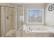 Elegant bathroom with a glass-enclosed shower and a large soaking tub by a window at 3887 Hickory Manor Dr, Suwanee, GA 30024